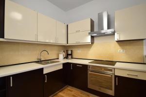 a kitchen with white cabinets and a sink at Diune Resort & Apartamenty in Kołobrzeg