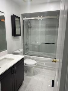 a bathroom with a toilet and a glass shower at Private room in a House in Mississauga