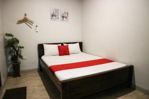 1 dormitorio pequeño con 1 cama con manta roja en K1 UPN, en Surabaya