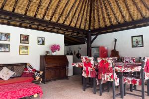 a room with a table and chairs and a guitar at Belvilla Pleasant Seaside Lovina Beach in Lovina +26 photos