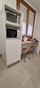 a microwave sitting on top of a refrigerator in a kitchen at Narciso Tomé en San justo 4 in Toledo