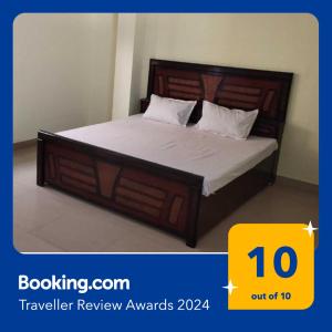 1 dormitorio con 1 cama con cabecero de madera en SPOT ON 81358 Sun Shine Hotel, en Jabalpur
