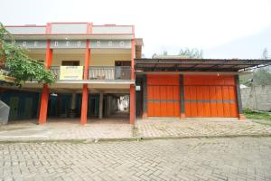 um edifício com portas cor-de-laranja ao lado em SPOT ON 93620 Anisa Homestay Syariah em Tulungagung