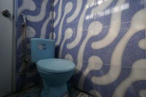 a bathroom with a blue toilet and a shower curtain at SPOT ON 93620 Anisa Homestay Syariah in Tulungagung