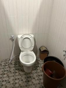 a bathroom with a toilet and a trash can at SPOT ON 93621 Kost Bu Tutik Syariah in Lawang