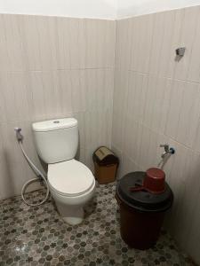 ein Badezimmer mit einem WC und einem Mülleimer in der Unterkunft SPOT ON 93621 Kost Bu Tutik Syariah in Lawang