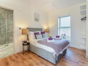 a bedroom with a bed and a glass shower at Fox Acre - Uk46236 in Usk