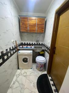 La petite salle de bains est pourvue d'un lavabo et d'un lave-linge. dans l'établissement شقة مودرن للايجار اليومي والاسبوعي, à Mansoura