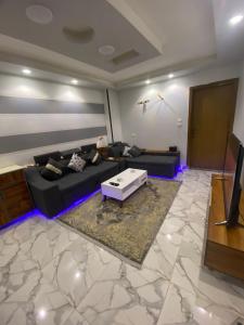 uma sala de estar com um sofá e uma mesa de centro em شقة مودرن للايجار اليومي والاسبوعي em Mansoura