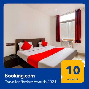 een hotelkamer met een bed met rode kussens bij OYO Flagship 80902 Swagat Hotel in Bhiwadi