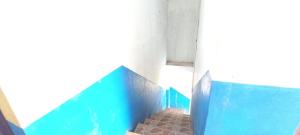 uma parede azul num quarto com piso em azulejo em SPOT ON 93622 Wisma Dua Putra Syariah em Majalengka