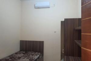 um pequeno quarto com uma cama e um armário em OYO 93625 Uno Homestay Syariah em Surabaya