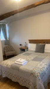 a bedroom with a bed with two towels on it at Church Farm Accommodation in Bickenhill