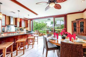 una cocina abierta con mesa, sillas y barra. en Ko Olina Beach Villas B107, en Kapolei