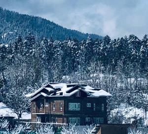 a house with snow on top of it at Sunset View Gulmarg in Gulmarg