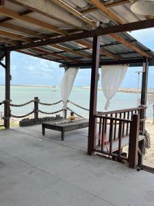 a pavilion on the beach with a view of the ocean at Rumahbatu beach cottage in Kuala Terengganu
