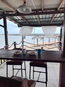 a table with chairs and a view of the beach at Rumahbatu Beach Cottage in Kuala Terengganu