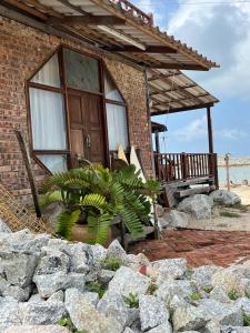 a brick house with a plant in front of it at Rumahbatu Beach Cottage in Kuala Terengganu