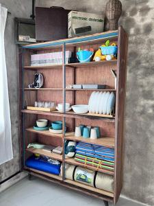 a wooden shelf with dishes and plates on it at Rumahbatu beach cottage in Kuala Terengganu