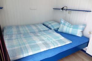 - un lit bleu avec 2 oreillers au-dessus dans l'établissement Möve Aba Bungalow 66, à Rerik