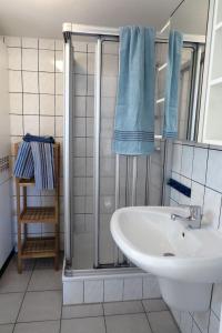 La salle de bains est pourvue d'un lavabo et d'une douche avec des serviettes bleues. dans l'établissement Möve Aba Bungalow 66, à Rerik