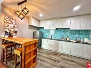 uma cozinha com uma mesa de madeira e um frigorífico em YM Homestay Vivacity megamall Jazz Suite 3 bedroom 8 pax em Kuching