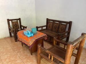 Habitación con 2 sillas, mesa, mesa y sillas. en OYO 93629 Villa Cemara Syariah, en Mojokerto
