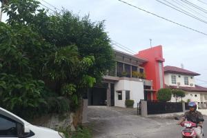 a man riding a motorcycle in front of a building at OYO 93635 Rumah Singgah Cemara Syariah in Pekanbaru