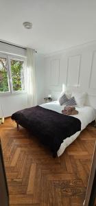 a bedroom with a large bed and wooden floors at Duplex climatisé 100m2, jardin, garage individuel clos in Antibes