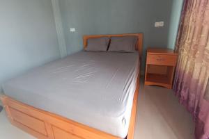 um pequeno quarto com uma cama e uma mesa de cabeceira em OYO 93638 Lotus Guest House em Lombok