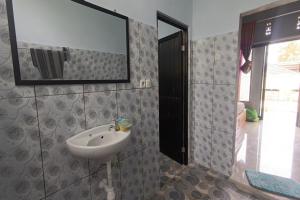 uma casa de banho com um lavatório e um espelho em OYO 93638 Lotus Guest House em Lombok