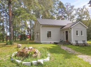 une petite maison blanche dans une cour dans l'établissement Pieni saneerattu hirsitalo koskenpartaalla, à Lapinjärvi