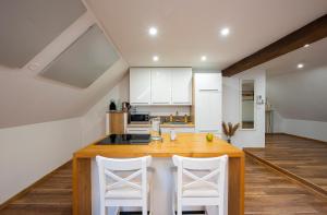 eine Küche mit einem Holztisch und weißen Stühlen in der Unterkunft Elevante Residence in Poprad