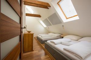 Schlafzimmer im Dachgeschoss mit 2 Betten und einem Fenster in der Unterkunft Elevante Residence in Poprad