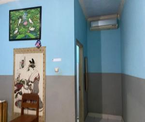 ein Zimmer mit blauen Wänden und einem Gemälde an der Wand in der Unterkunft SPOT ON 93639 Kaila Guesthouse in Lombok