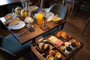 una mesa con alimentos para el desayuno y zumo de naranja en ella en DOURWIN - Riverside Suites - Adults Only en Penafiel