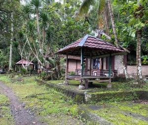 um pequeno edifício com um banco ao lado de uma estrada em OYO 93638 Lotus Guest House em Lombok