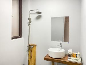a bathroom with a sink and a lamp on a table at Dali Erhai Forest River View Hostel in Dali +22 photos