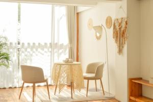 mesa y sillas en una habitación con ventana en Dali Erhai Forest River View Hostel, en Dali