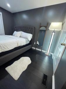 a bedroom with a bed and a mirror and a white rug at Private room in a House in Mississauga