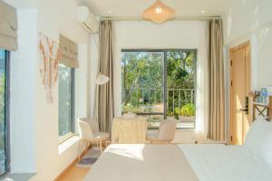 a bedroom with a bed and a large window at Dali Erhai Forest River View Hostel in Dali