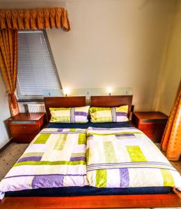um quarto com uma cama com duas almofadas e uma janela em Apartman De Lux em Nyíregyháza