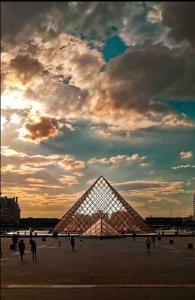 een piramidevormig gebouw onder een bewolkte hemel bij Studio 1 Adorable studio neuf en bord de Marne 5kms Paris in Champigny-sur-Marne