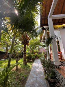 a courtyard with palm trees in a building at Wahyu Masari Homestay in Nusa Penida