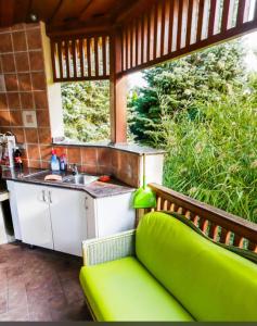 a kitchen with a green couch on a patio at Apartman De Lux in Nyíregyháza