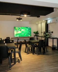 a restaurant with tables and chairs and a large screen at Inizio Hotel Boutique Laureles in Medellín