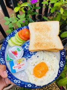 a plate with an egg and toast and fruit at SRL Villa in Phumi Ta Phul