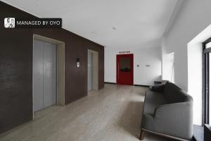 ein Wohnzimmer mit einem Sofa und einer roten Tür in der Unterkunft Super Townhouse OMR Laxmi Nagar in Chennai