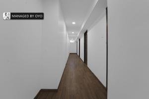 a hallway with white walls and wood floors and a sign that reads marked by ox at Super Townhouse OMR Laxmi Nagar in Chennai