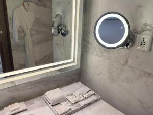 baño con espejo y lavabo con toallas en Le Méridien Amritsar en Amritsar